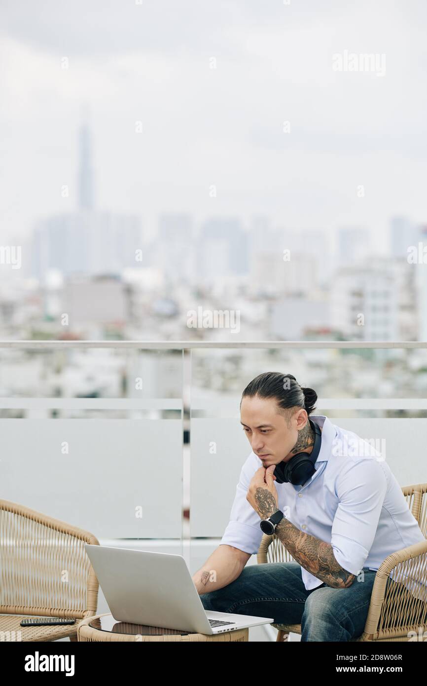 Pensive man working on rooftop Stock Photo
