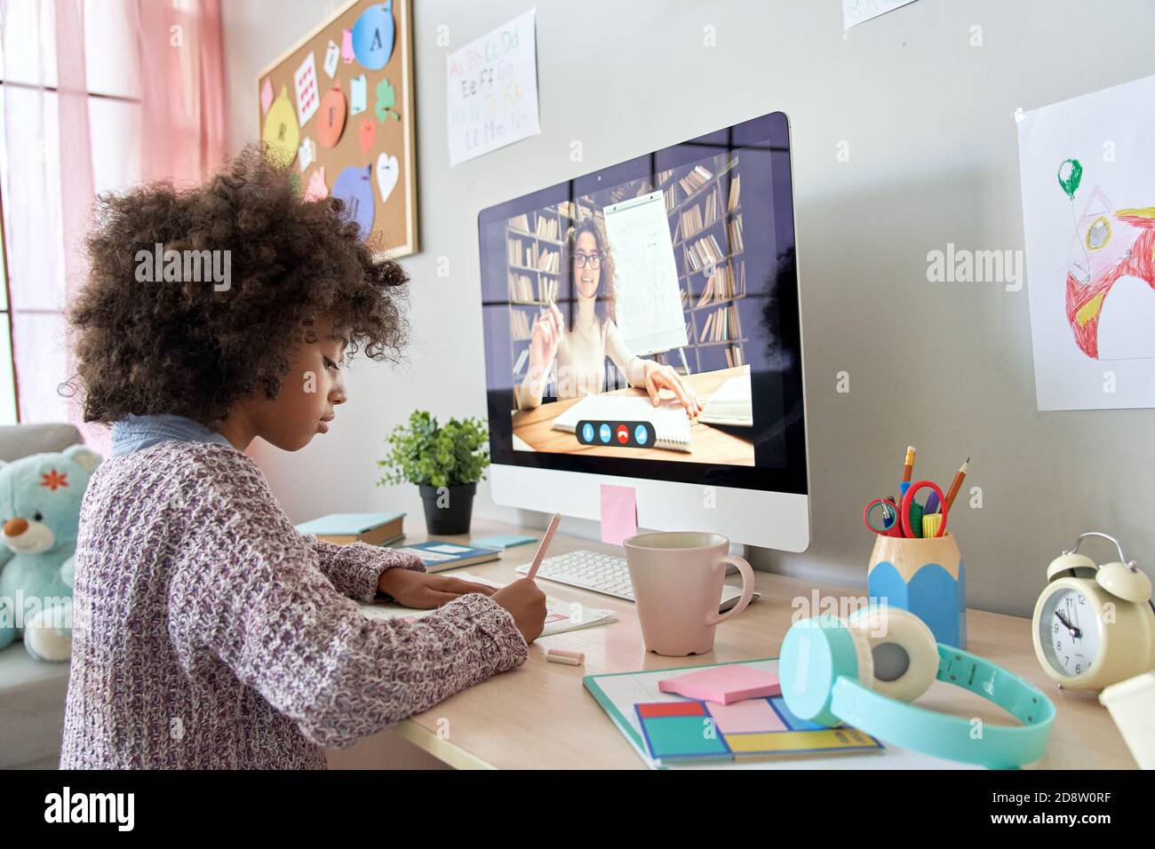 African school kid girl distance learning with online teacher at home. Stock Photo