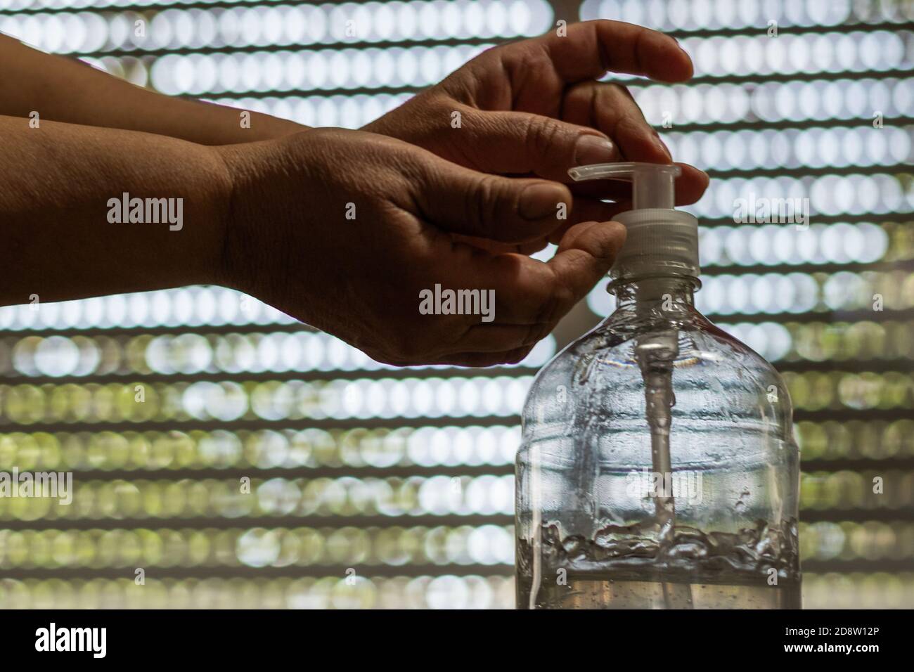 Closeup shot of hands pumping sanitizer out of a plastic botte Stock Photo  - Alamy