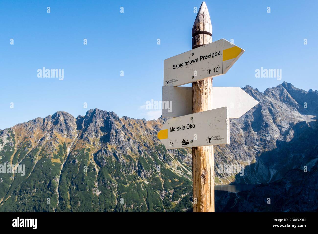 Mountain trail wooden directional sign in Tatra Mountains, pointing direction to Morskie Oko lake (Eye of the Sea) and Szpiglasowa Przelecz Pass. Stock Photo