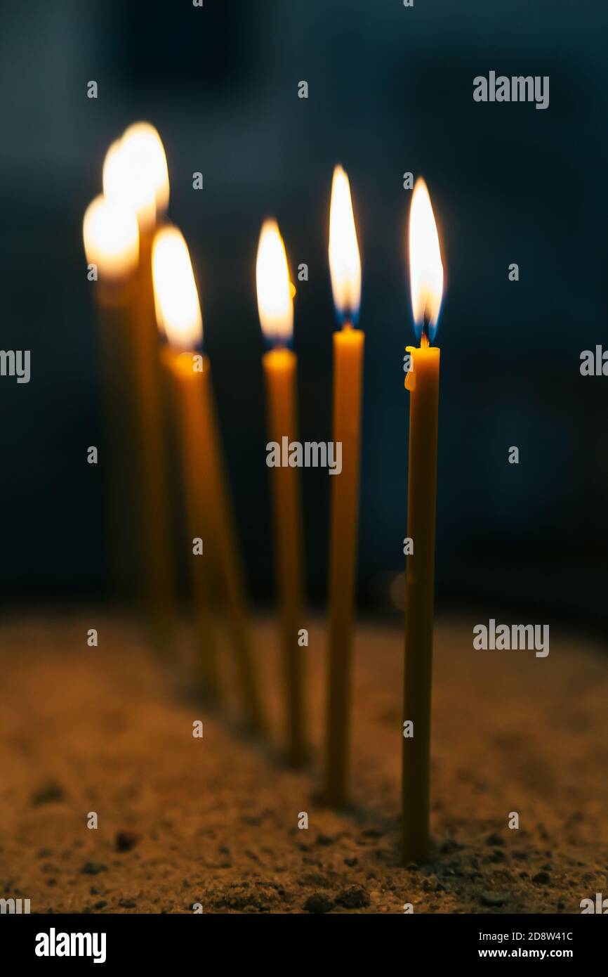 Burning candles in a church on a dark background. Details in the
