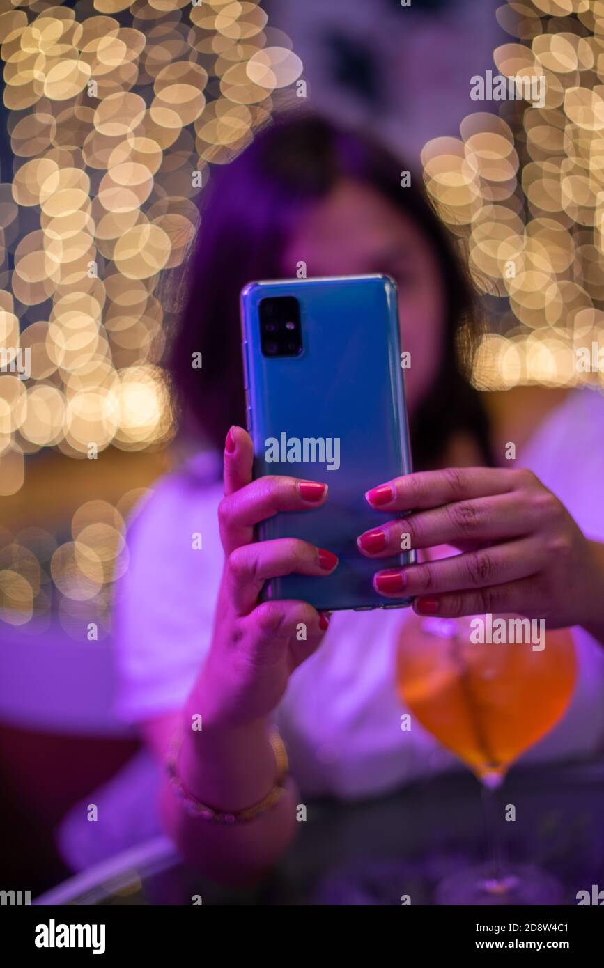 Woman using her mobile phone with blurred background Stock Photo