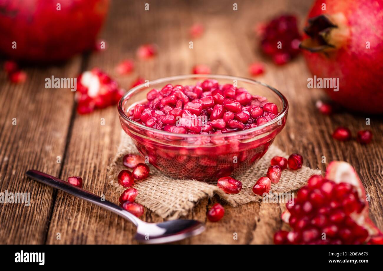Vintage wooden table with preserved Pomegranate seeds (selective focus; close-up shot) Stock Photo