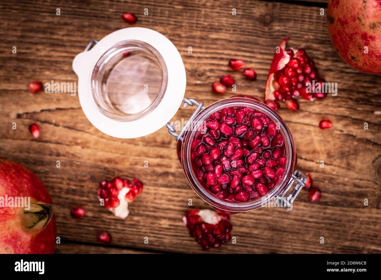 Portion of healthy preserved Pomegranate seeds on an old wooden table (selective focus; close-up shot) Stock Photo