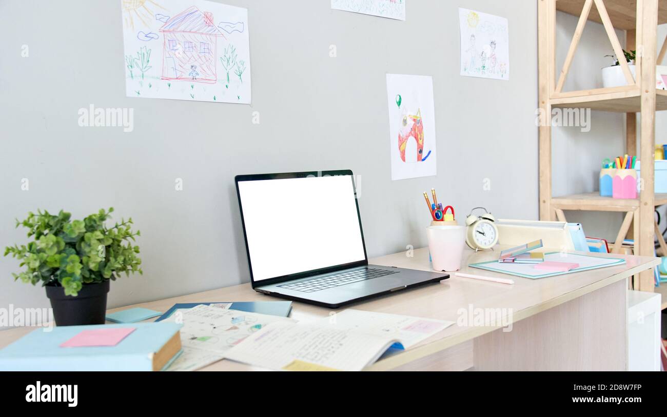 Table with white mock up computer screen for online virtual distance learning. Stock Photo