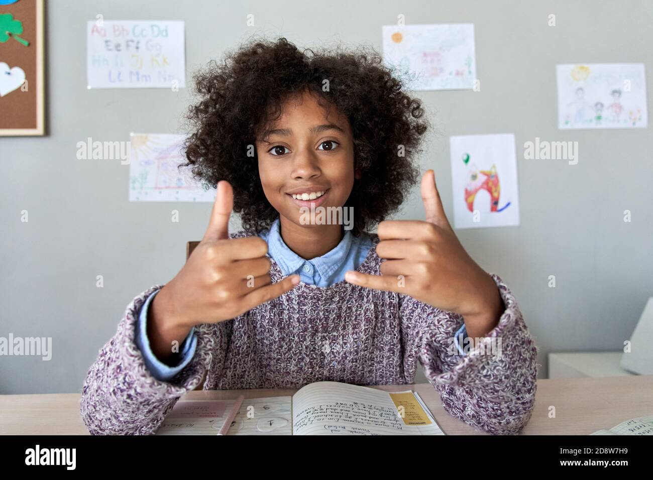African deaf kid girl showing sign language gesture looking at camera. Stock Photo