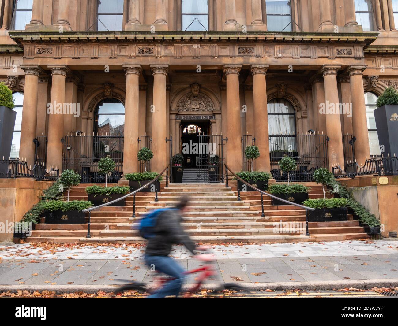A cyclist passes the Merchant Hotel, Waring Street, Belfast, Northern Ireland during lock down Stock Photo