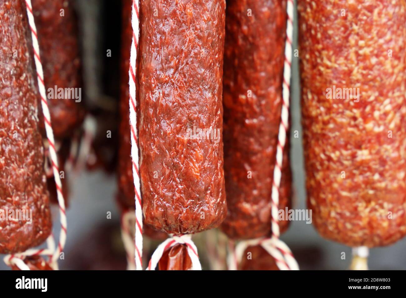 Sausage sticks are hanging in the store. Production and sale of meat
