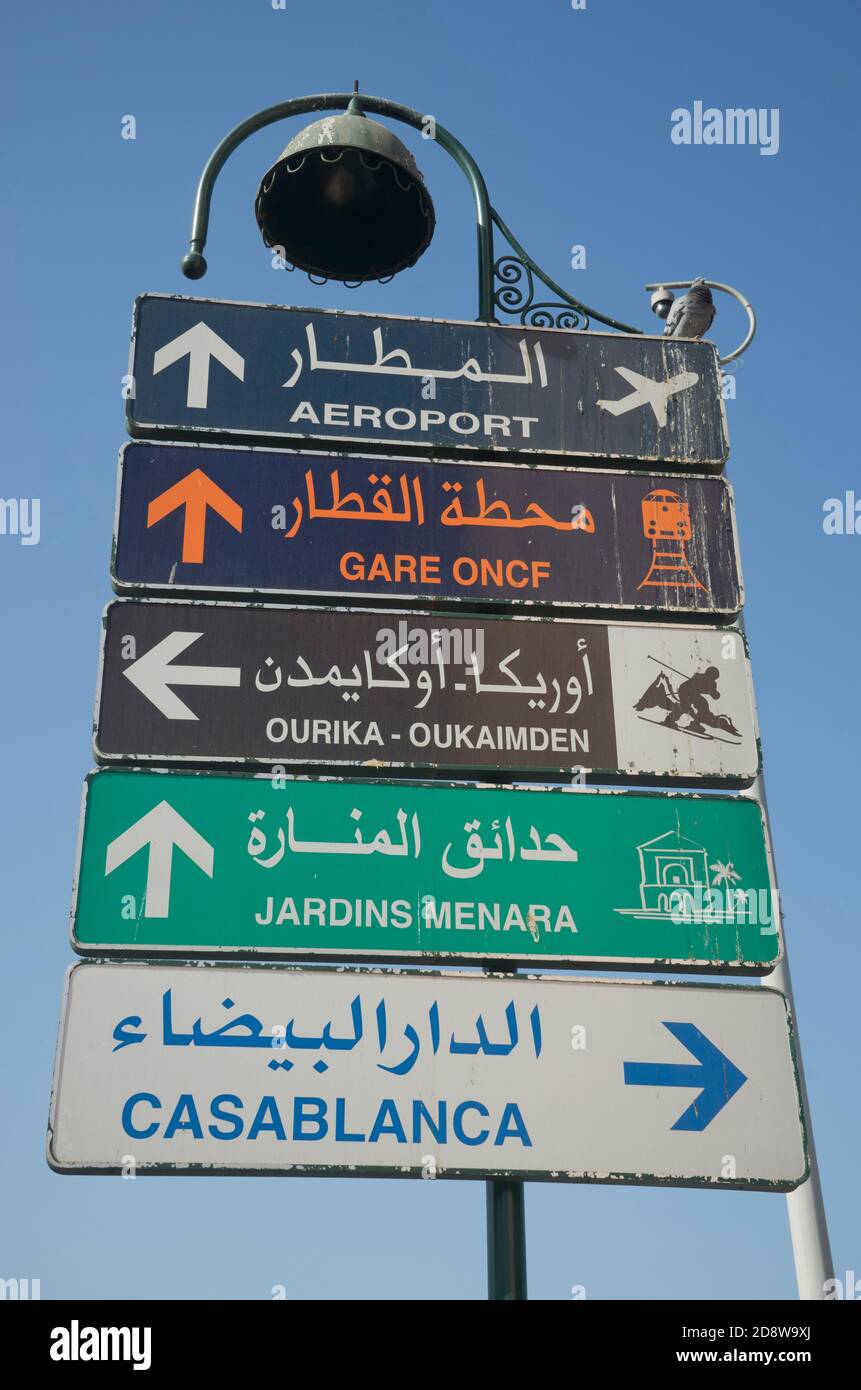 Road signs by medieval wall ramparts and the medina old town in Marrakesh, Morocco Stock Photo