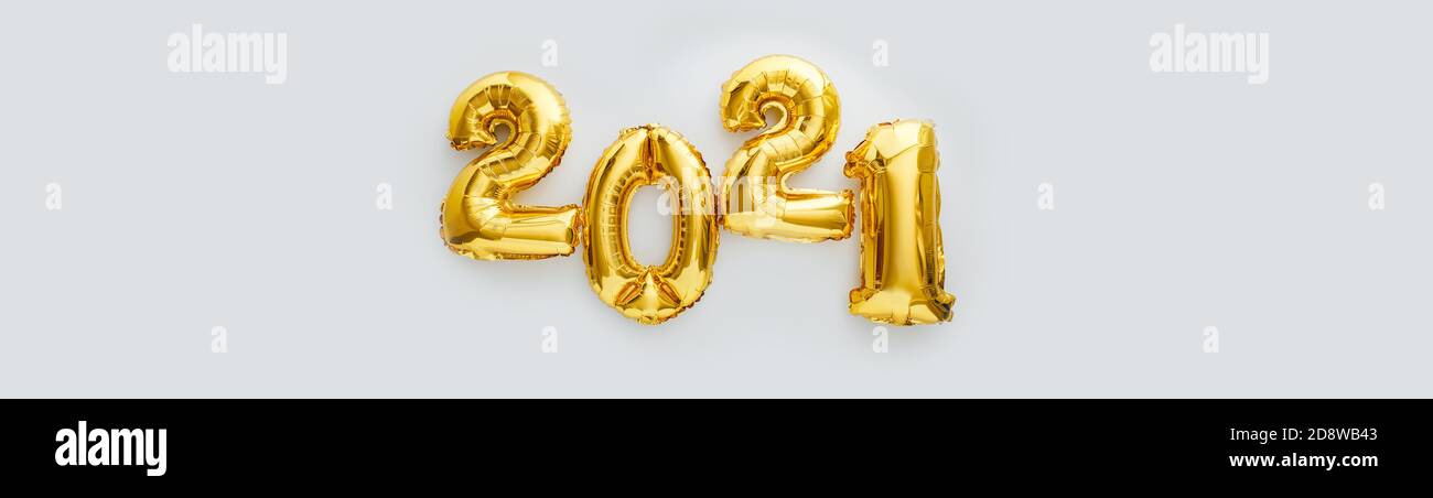2021 balloon text on white background. Happy New year eve invitation with Christmas gold foil balloons 2021. Flat lay long web banner with copy space Stock Photo