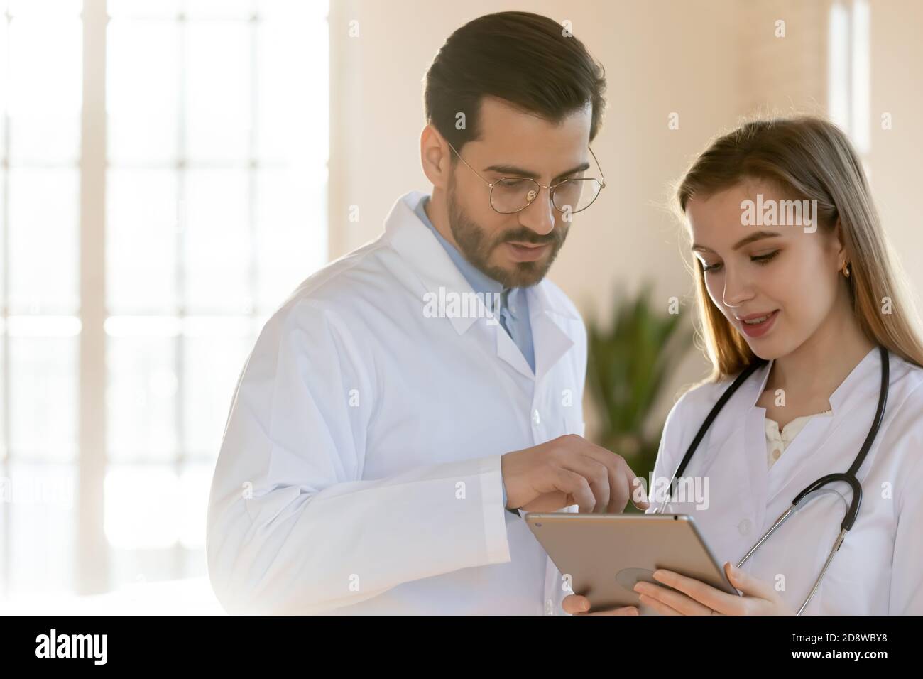 Two doctors male and female colleagues working on digital tablet Stock Photo