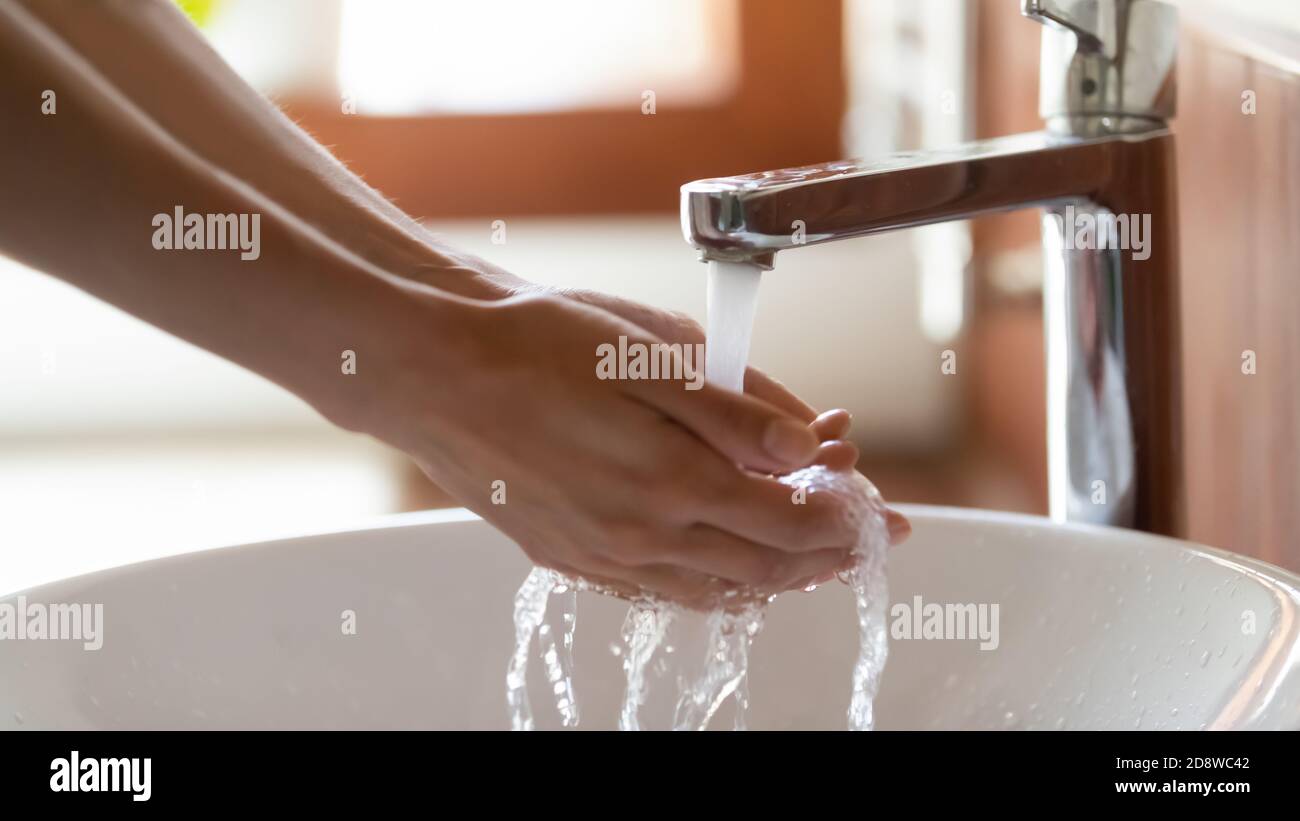 Close up of female washing hands in sink at bathroom Stock Photo