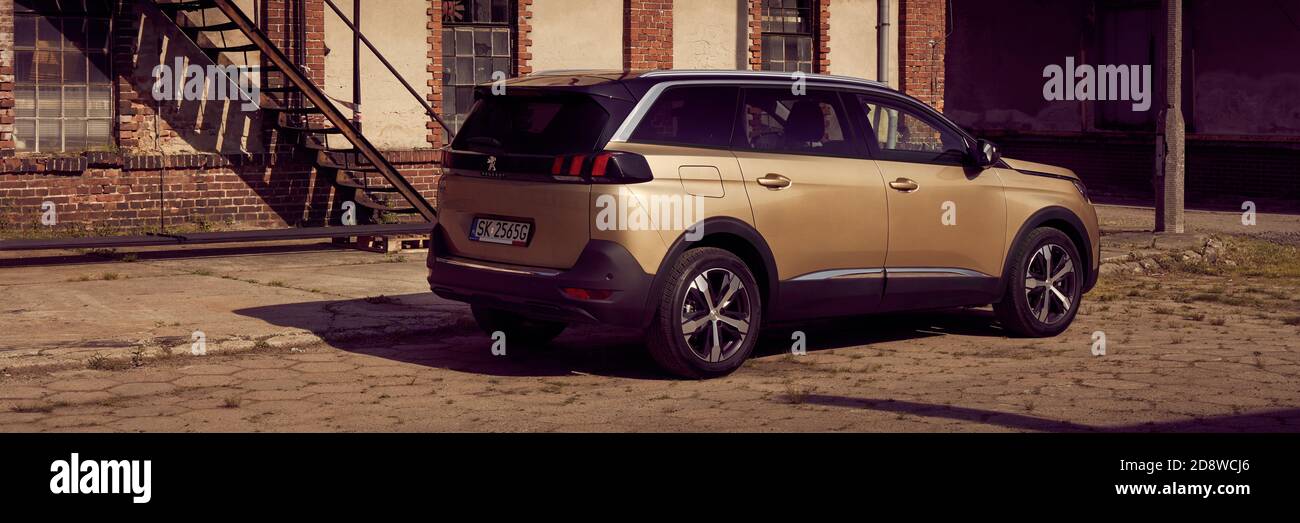 Tychy/Poland - 06.03.2017: Golden Peugeot 5008, a seven-person SUV, parked next to the old Civic Brewery building. There are no people. Stock Photo
