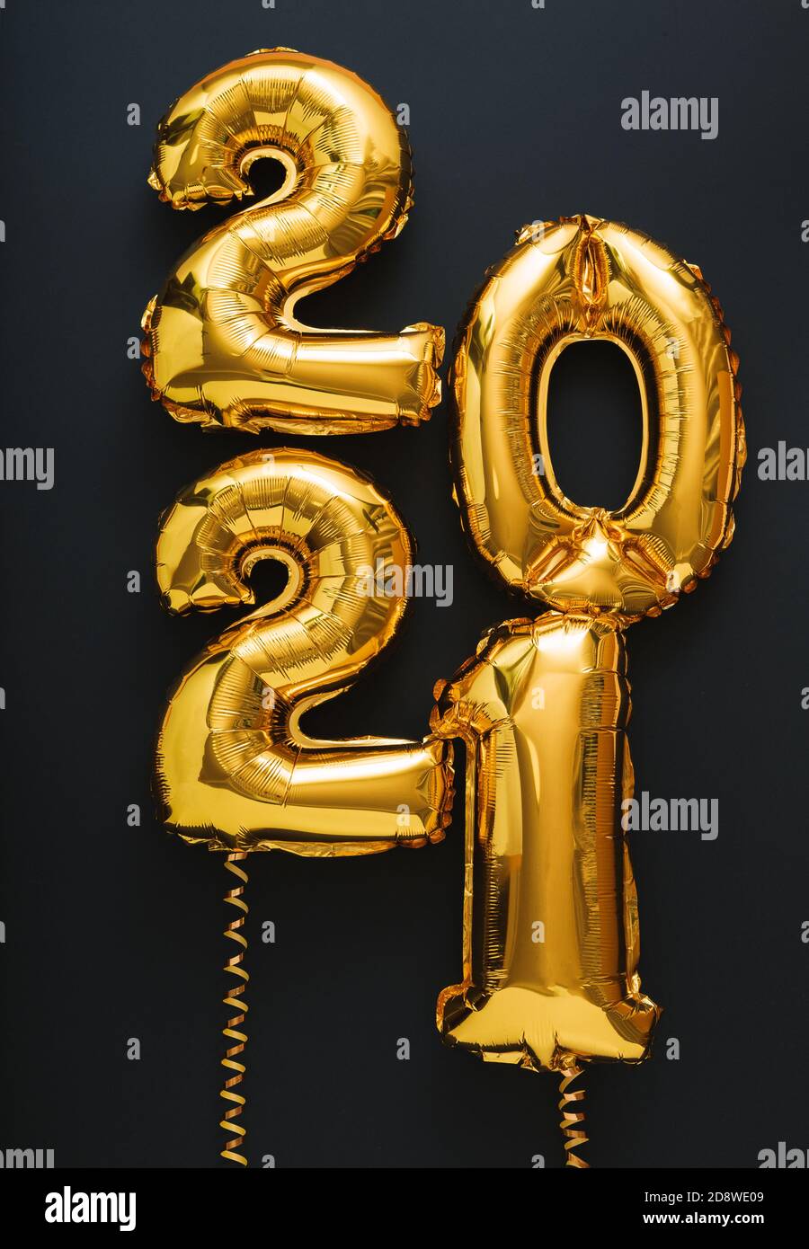 2021 balloon gold text on black background. Happy New year eve invitation with Christmas gold foil balloons 2021. Vertical Stock Photo