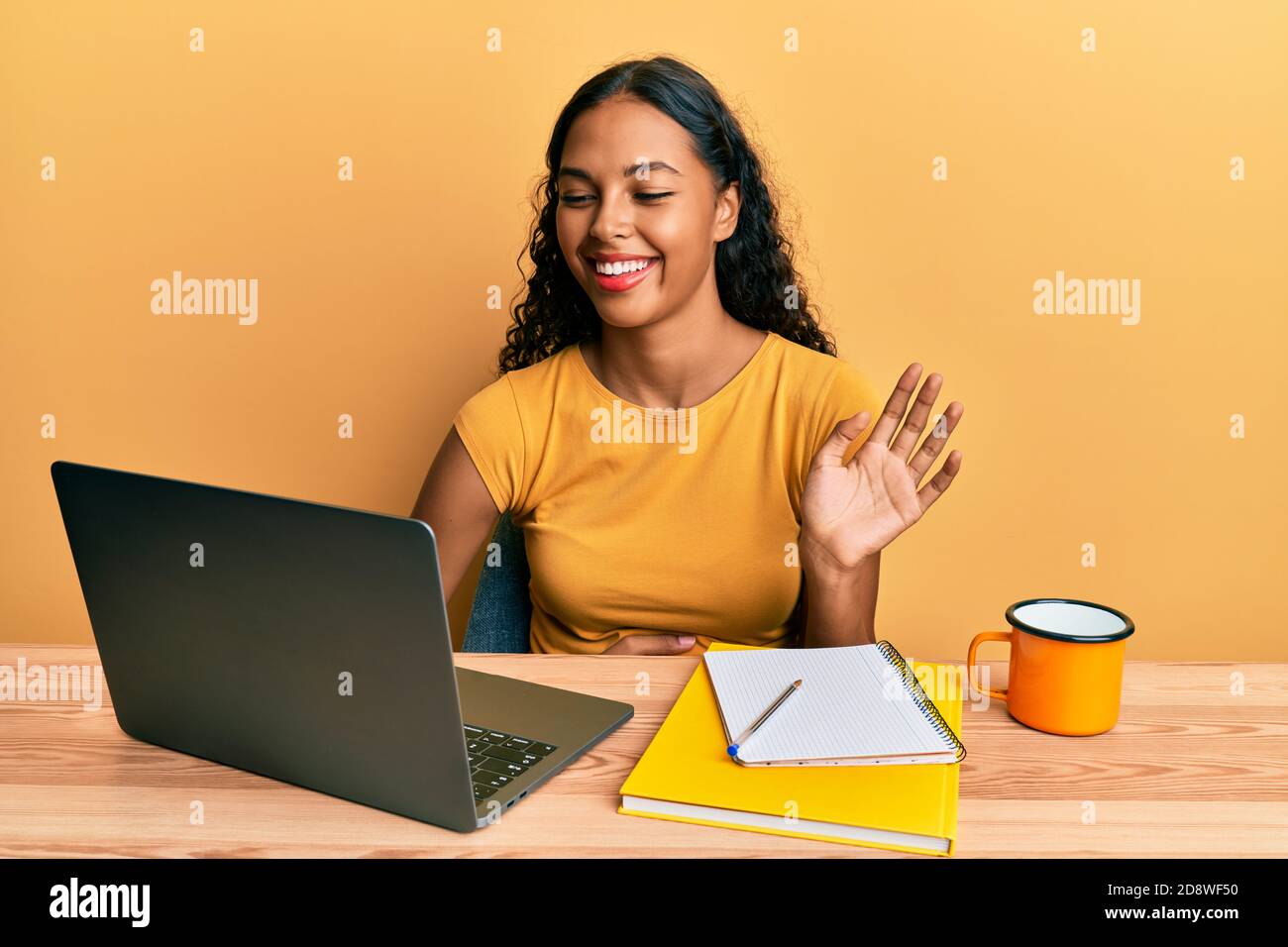 Young african american girl doing video call waving to laptop smiling ...