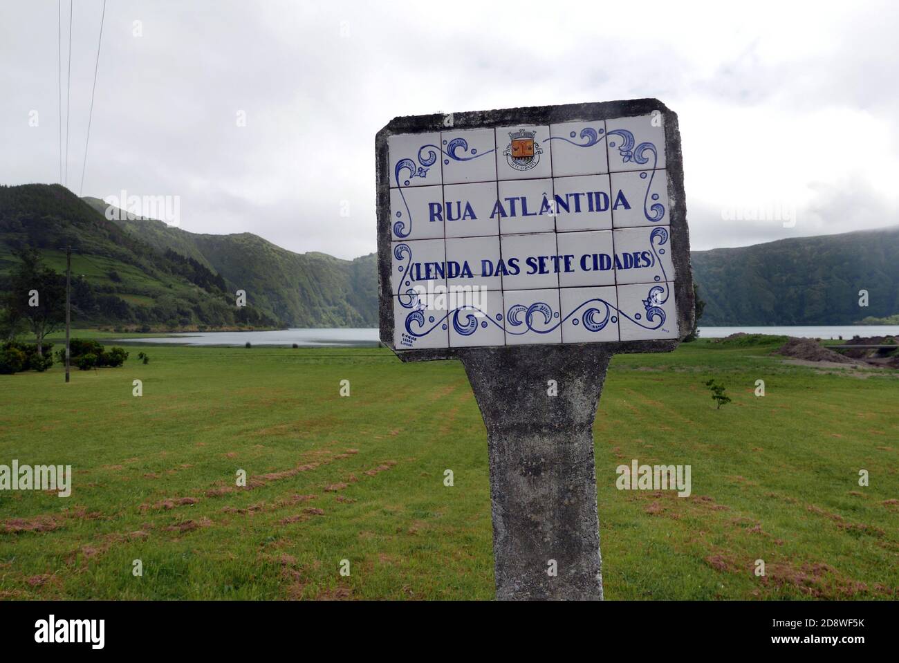 A concrete and ceramic street sign in the caldera village of Sete Cidades on the island of Säo Miguel in the Azores refers to the legend of Atlantis. Stock Photo