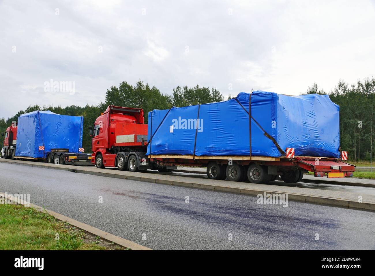A trucks with a special semi-trailers for transporting oversized loads. Oversize load or exceptional convoy. Stock Photo