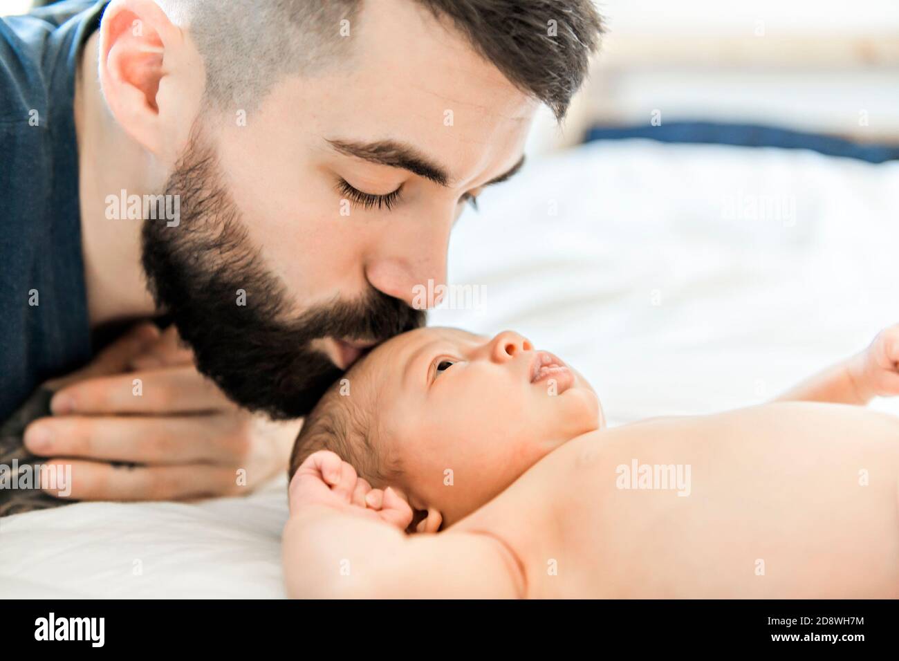 father lay on bed with his newborn baby daughter Stock Photo