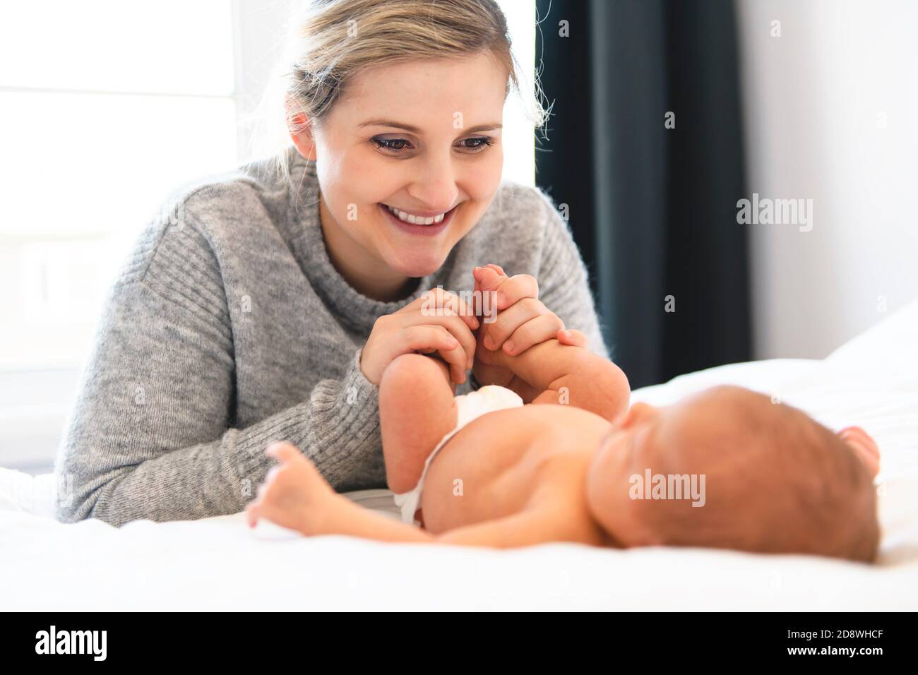 Mother lay in bed with his newborn baby daughter Stock Photo Alamy