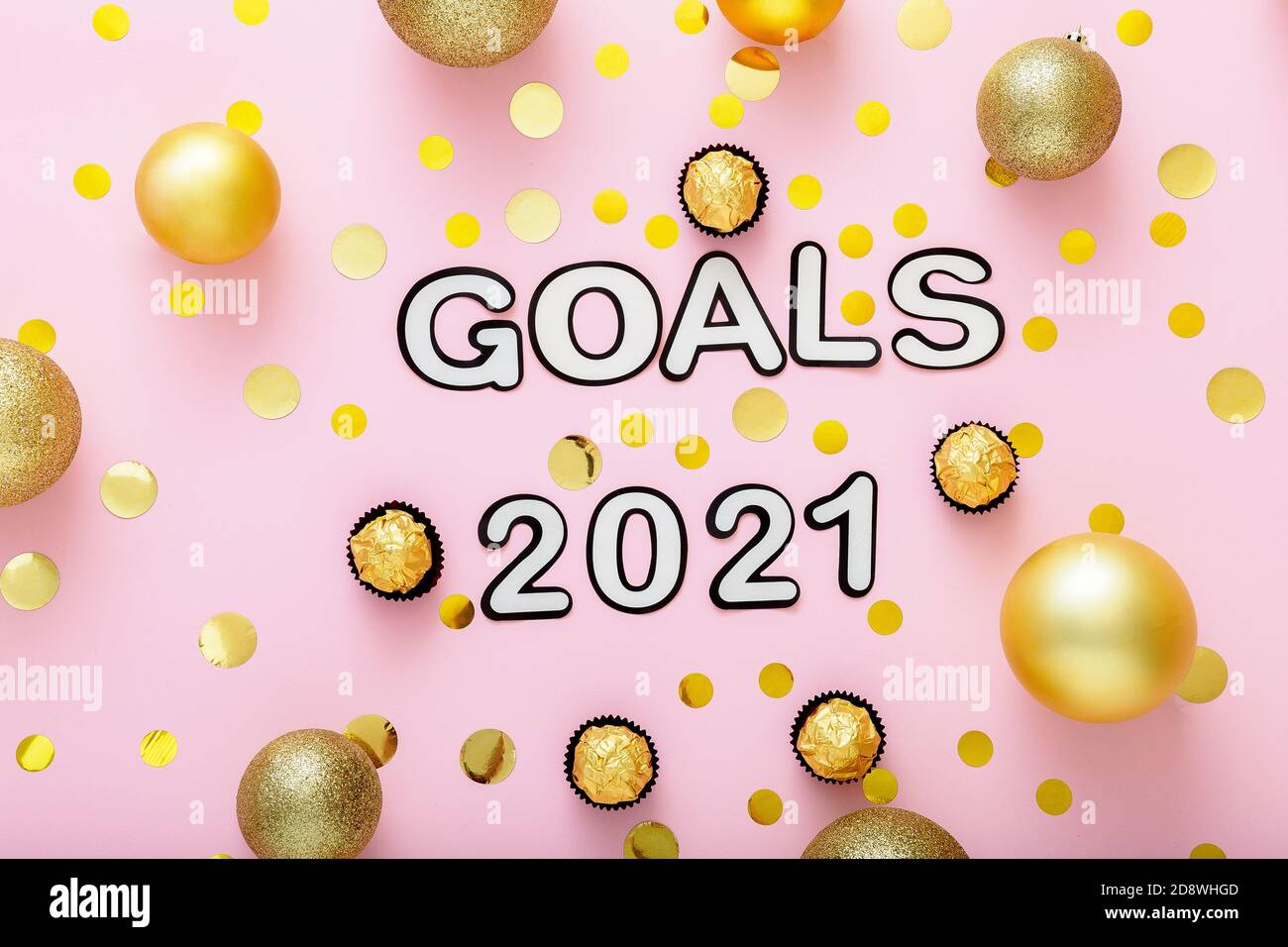2021 Goals lettering on pink background with fastive christmas decor, golden confetti, balls. New year eve 2021 goals. Stock Photo