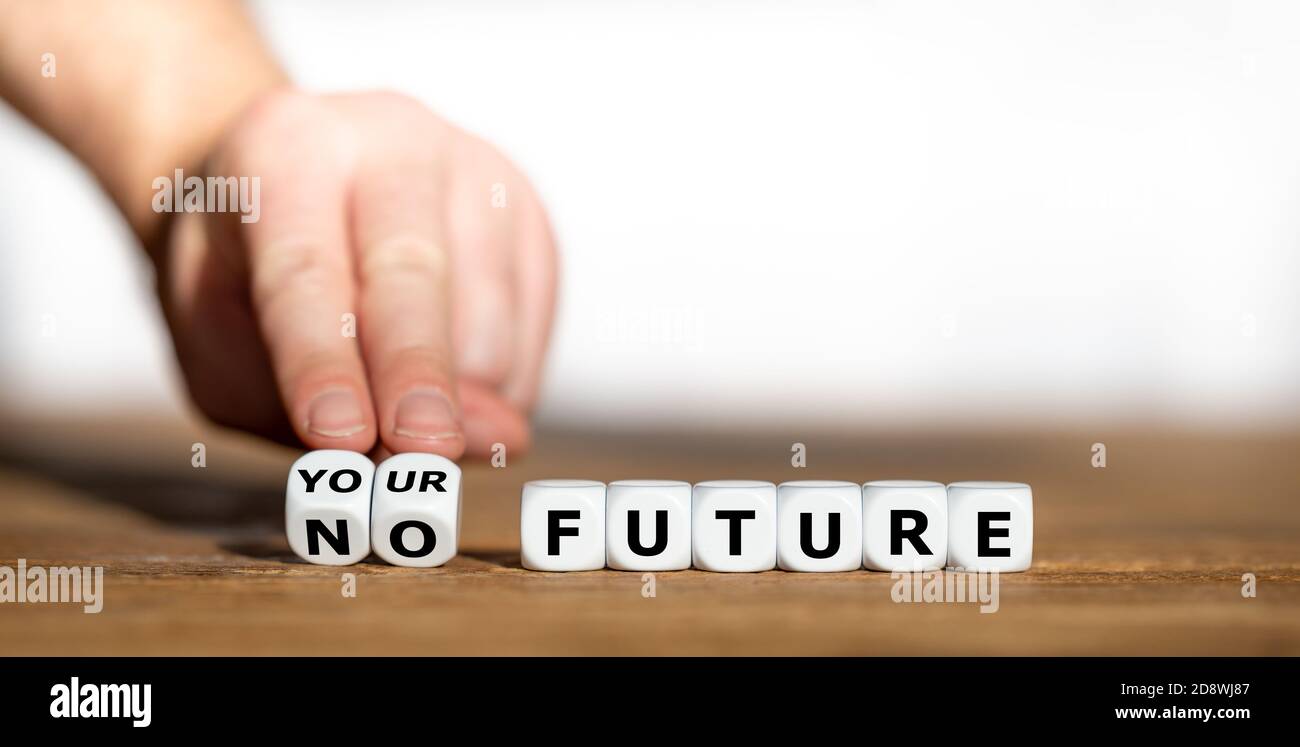 Hand turns dice and changes the expression 'no future' to 'your future'. Stock Photo