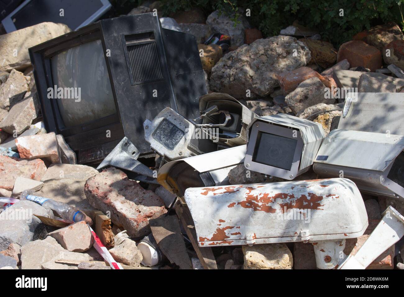 Discarded surveillance cameras and TV monitor amongst rubble.  Comment on dystopian society and possible 'Big Brother' 1984 suggestions. Stock Photo