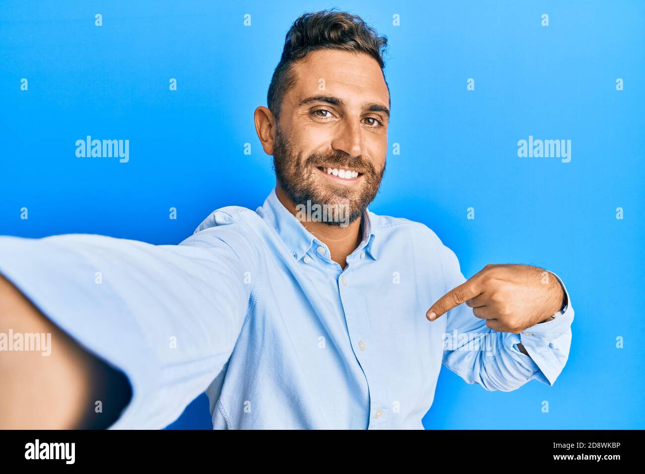 Handsome man with beard taking a selfie photo with smartphone pointing ...