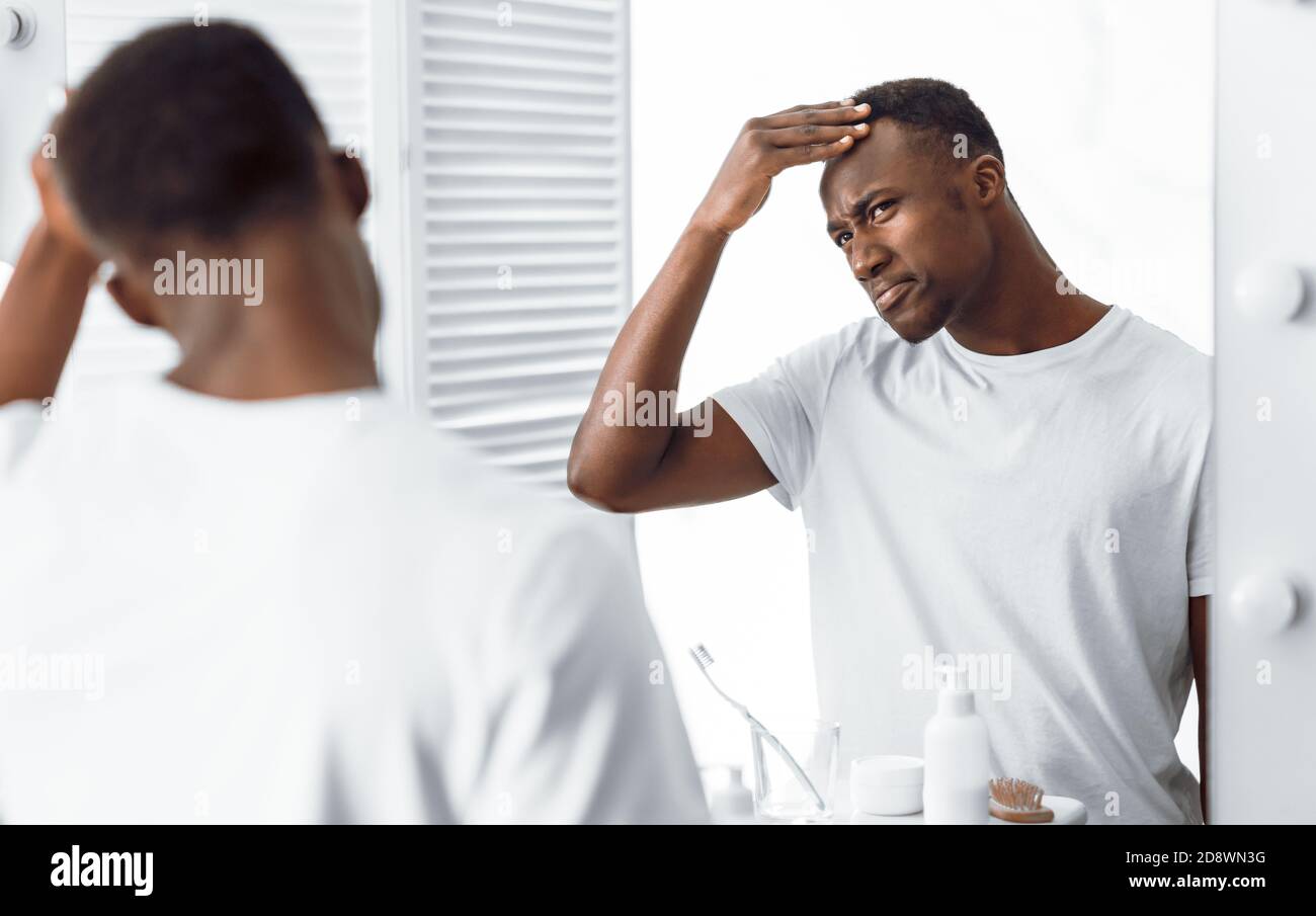 Black Guy Examining His Head Searching Gray Hair In Bathroom Stock Photo