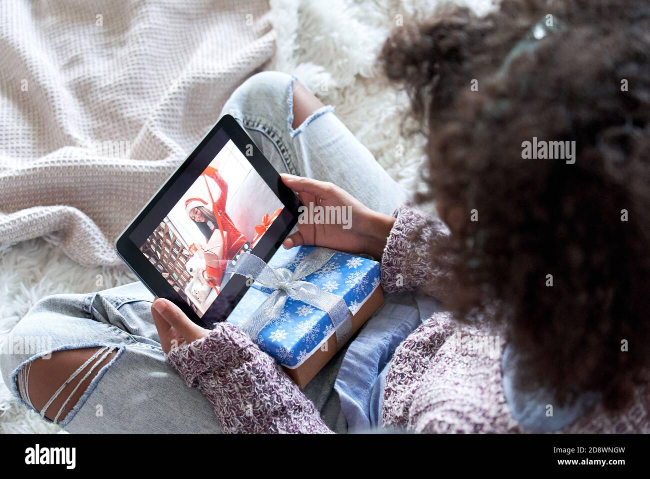 African kid girl talking to friend on video conference online call opening gift. Stock Photo