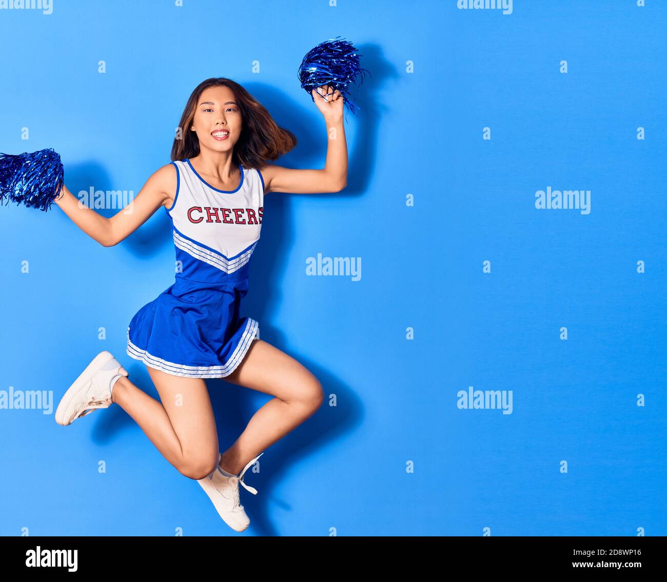 Young beautiful chinese girl smiling happy wearing cheerleader uniform