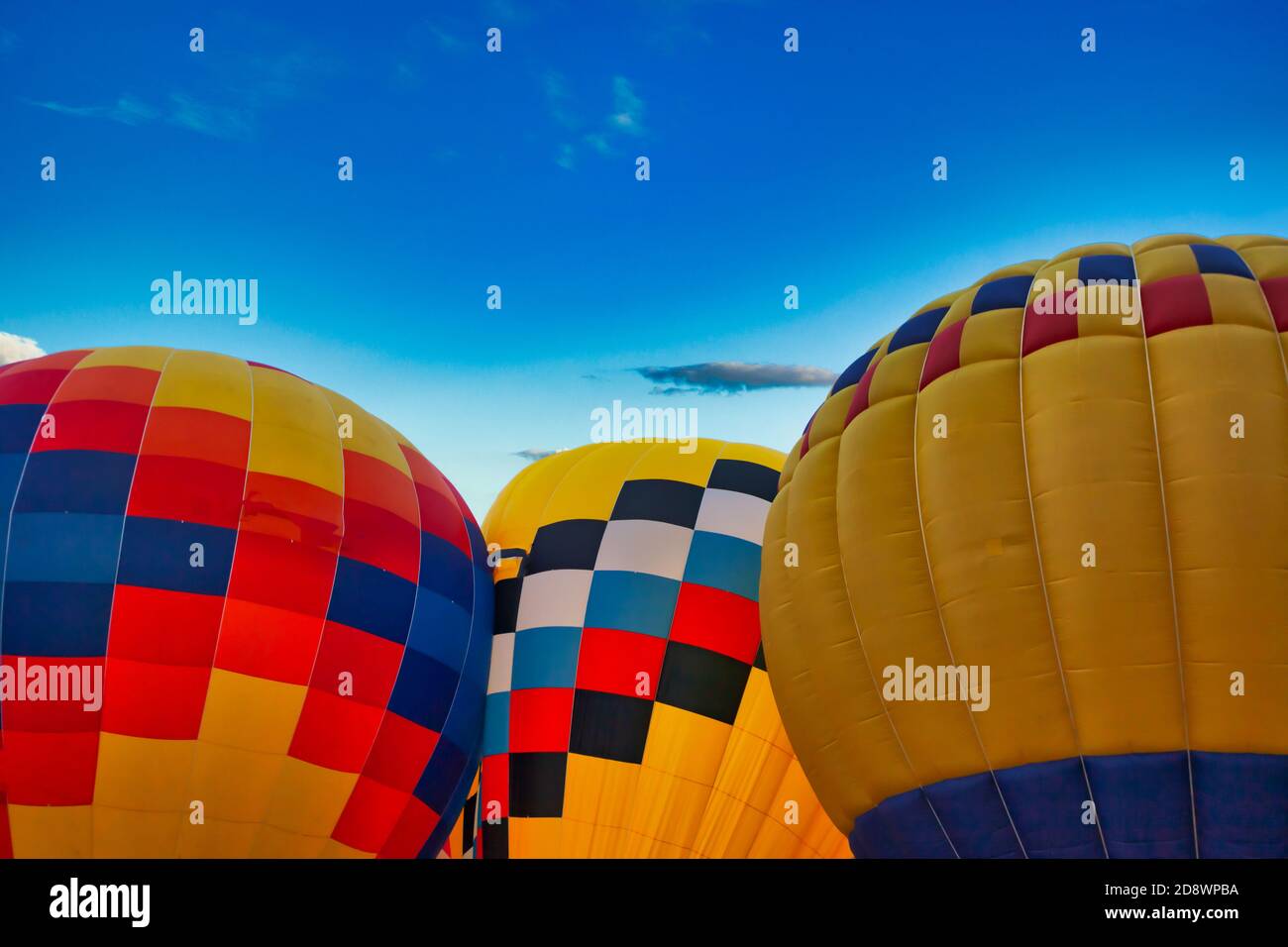 three multicolored balloons against the blue sky Stock Photo