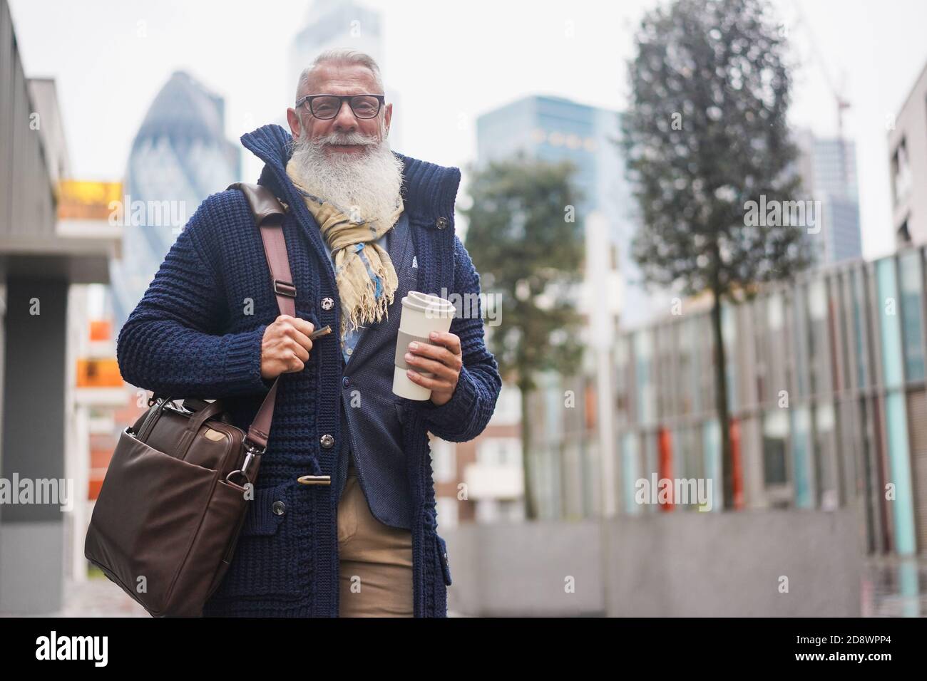 Senior hipster businessman drinking coffee in the city on winter day - Focus on face Stock Photo
