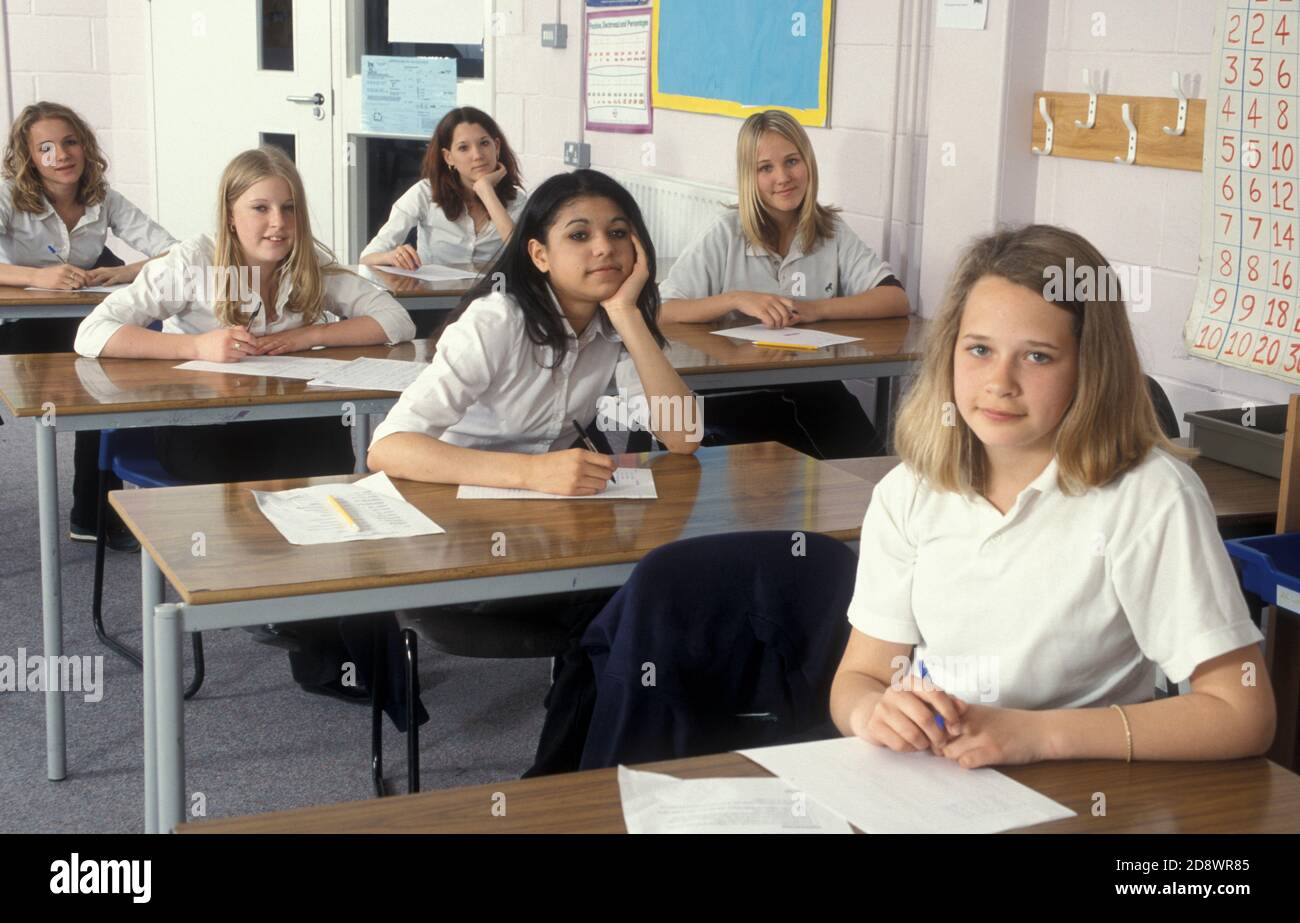 Six female high school students sitting at separate school desks