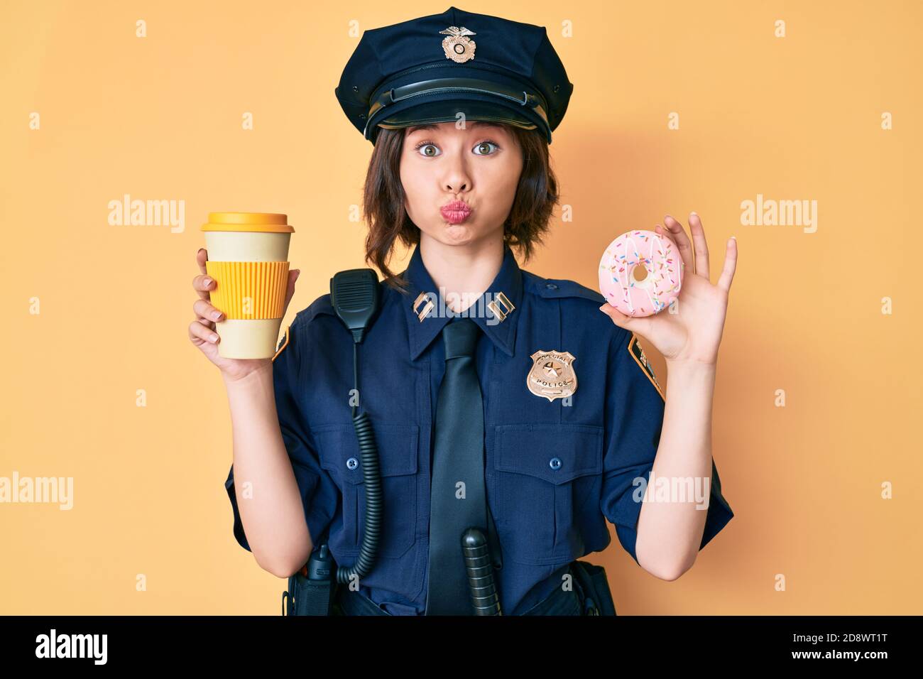 Young beautiful woman wearing police uniform holding donut and take away  coffee puffing cheeks with funny face. mouth inflated with air, catching  air Stock Photo - Alamy