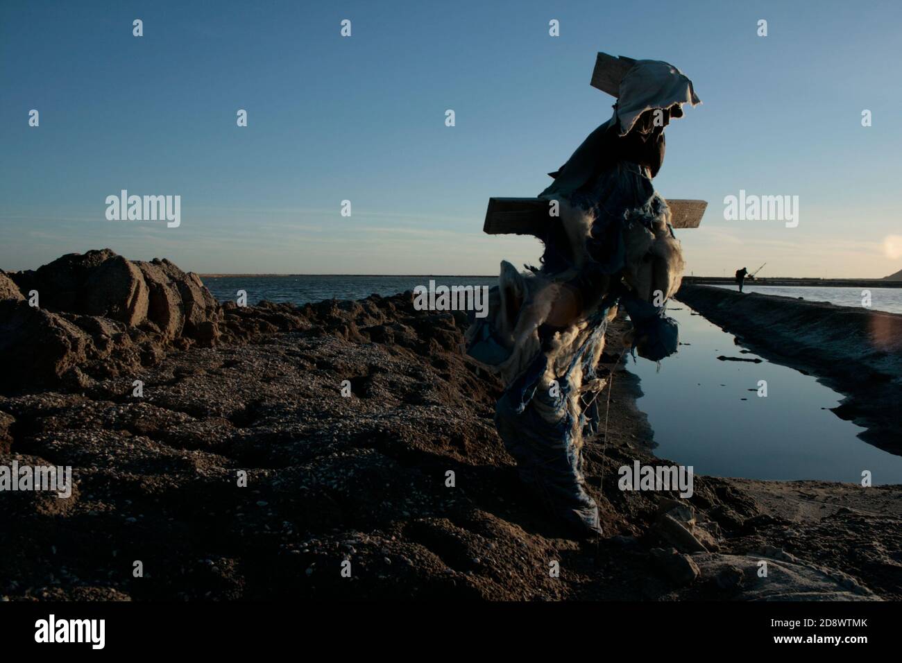 The scarecrow of Sfax saline with sunset winter and blue sky reflection on water. Tunisia Stock Photo