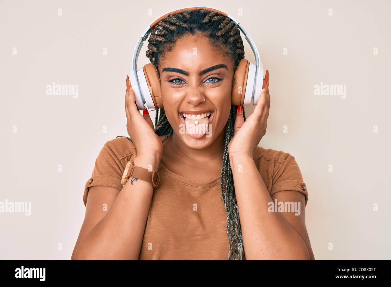 Young african american woman with braids listening to music using ...