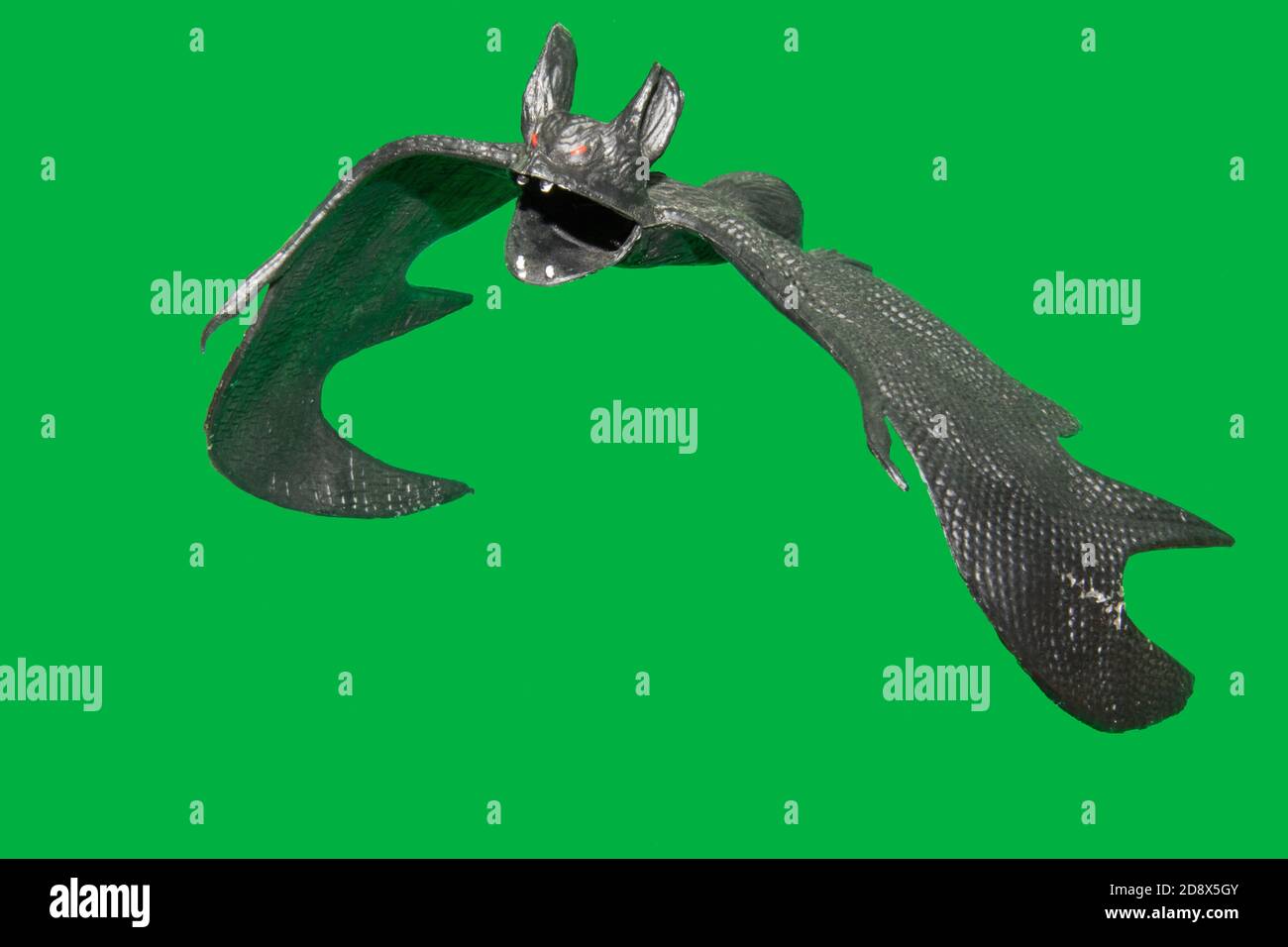 A black plastic bat suspended in mid air surrounded by a green screen Stock Photo Alamy