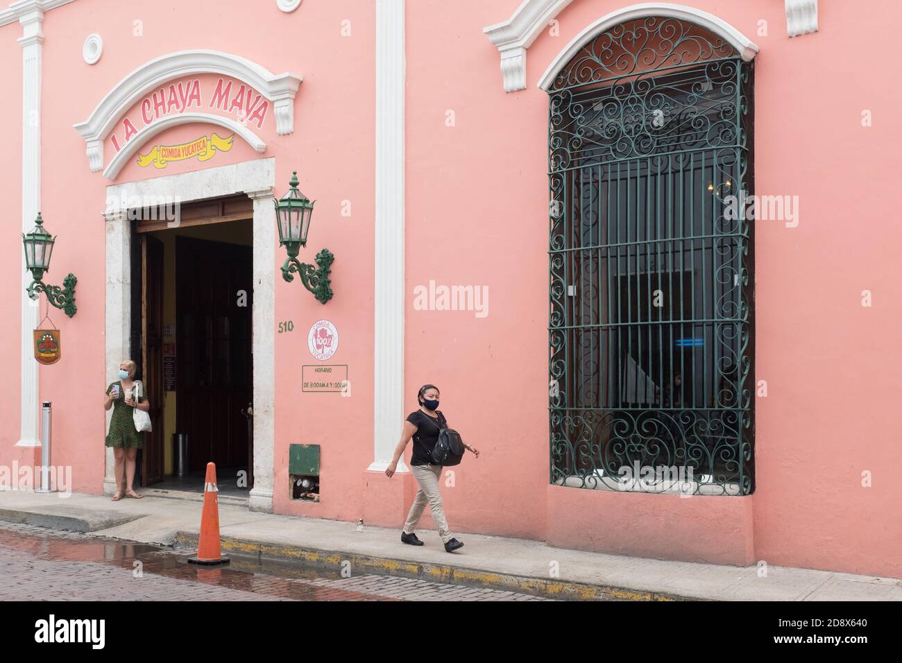 Lonely tourist in front of a restaurant: in a mostly empty downtown Merida during the Covid19 Pandemic, November 2020 - Many shops being closed and many businesses went out of business because of the Coronavirus restrictions. Merida, Yucatan, Mexico Stock Photo