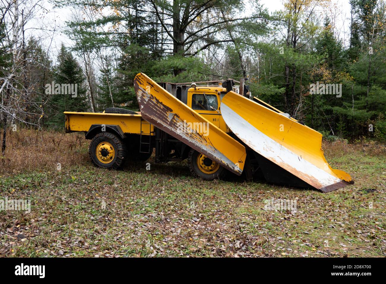 An old heavy-duty snow plow truck parked in a remote area of the Adirondack Mountains, NY USA for use keeping logging roads open in winter. Stock Photo
