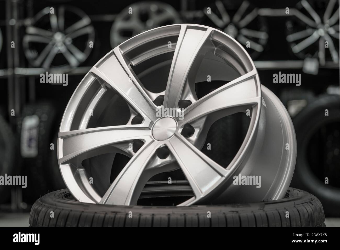 silver alloy wheel on a tire in a car spare parts store Stock Photo Alamy
