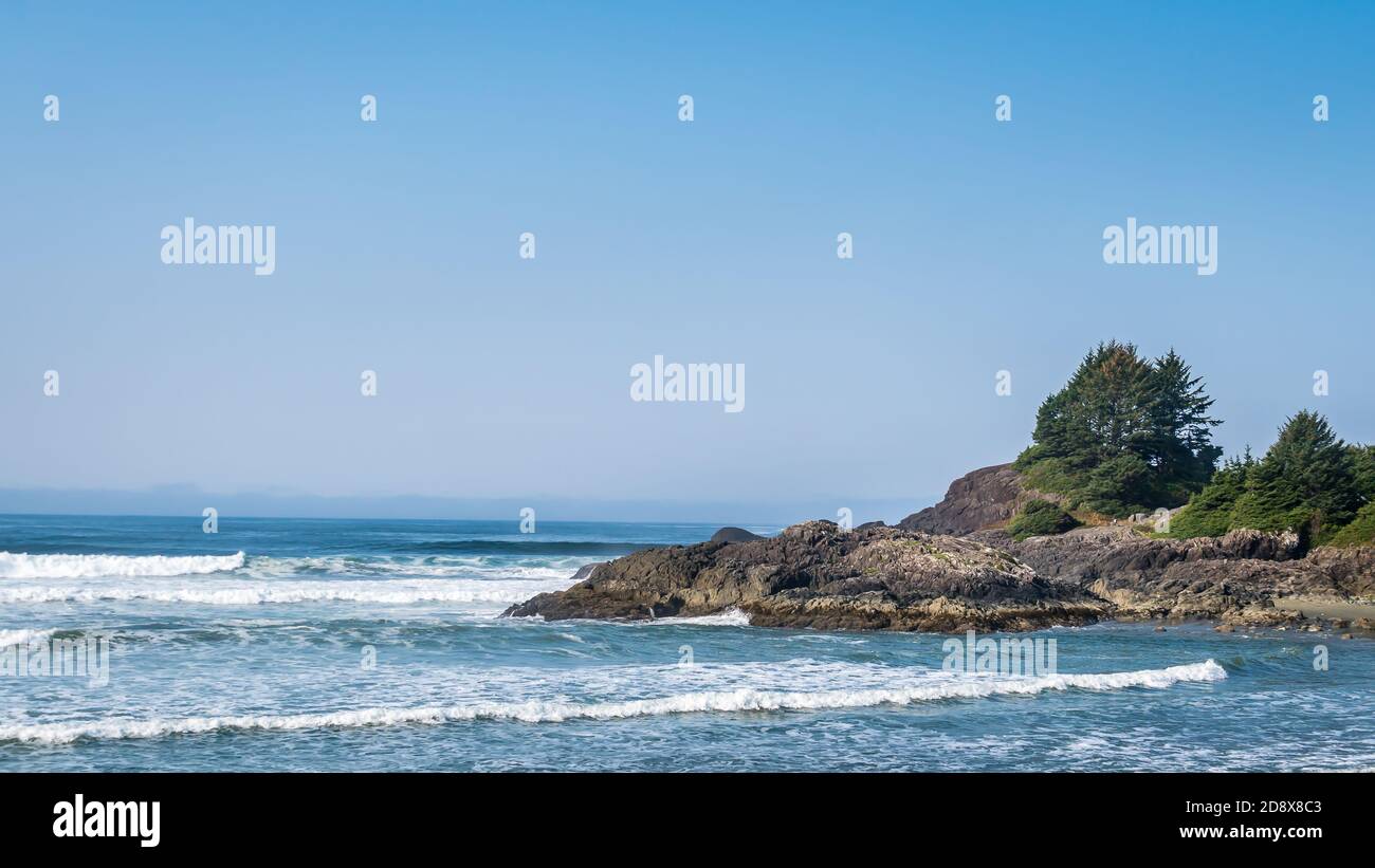 The rocky shore between Cox Bay and Chesterman Beach at the Pacific Rim National Park on Vancouver Island, British Columbia, Canada under Blue Sky Stock Photo