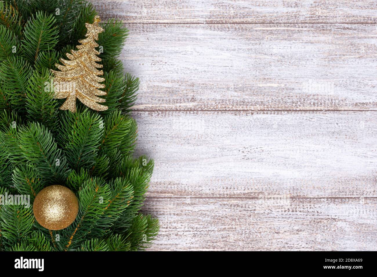 mock up, gold decorations on Christmas tree branches on a wooden background Stock Photo