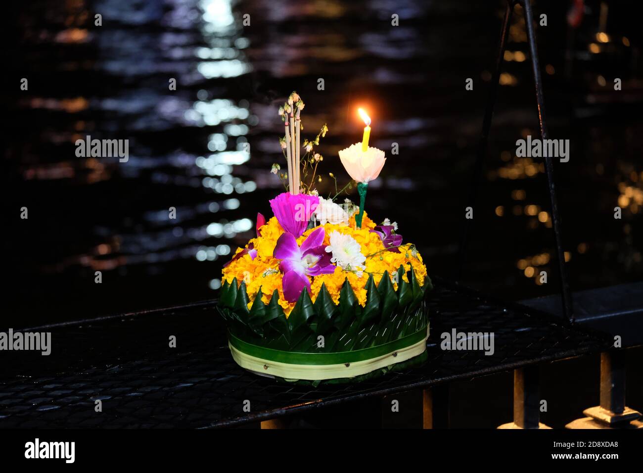 Flower cockerel with candle and incenses by the river 1 Stock Photo