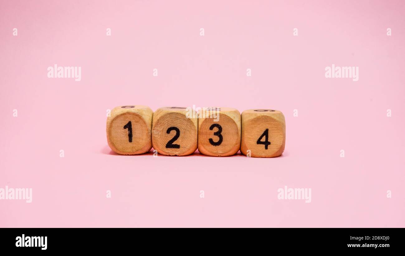 Four wooden dice on pink background Stock Photo