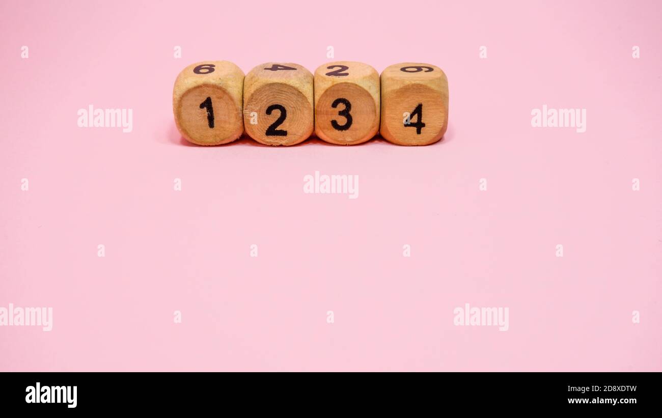 Four wooden dice on pink background Stock Photo