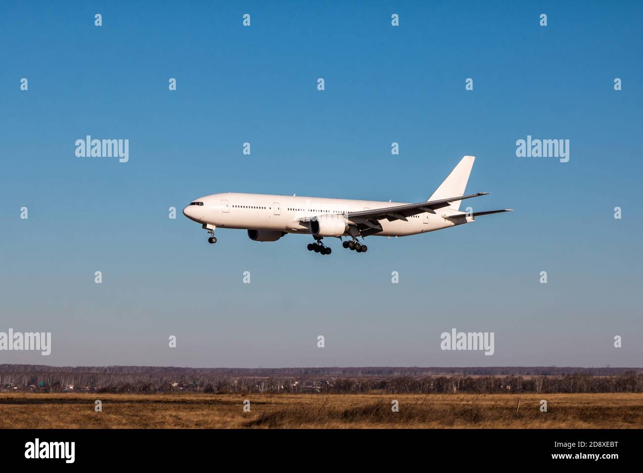 Landing white wide-body passenger aircraft Stock Photo