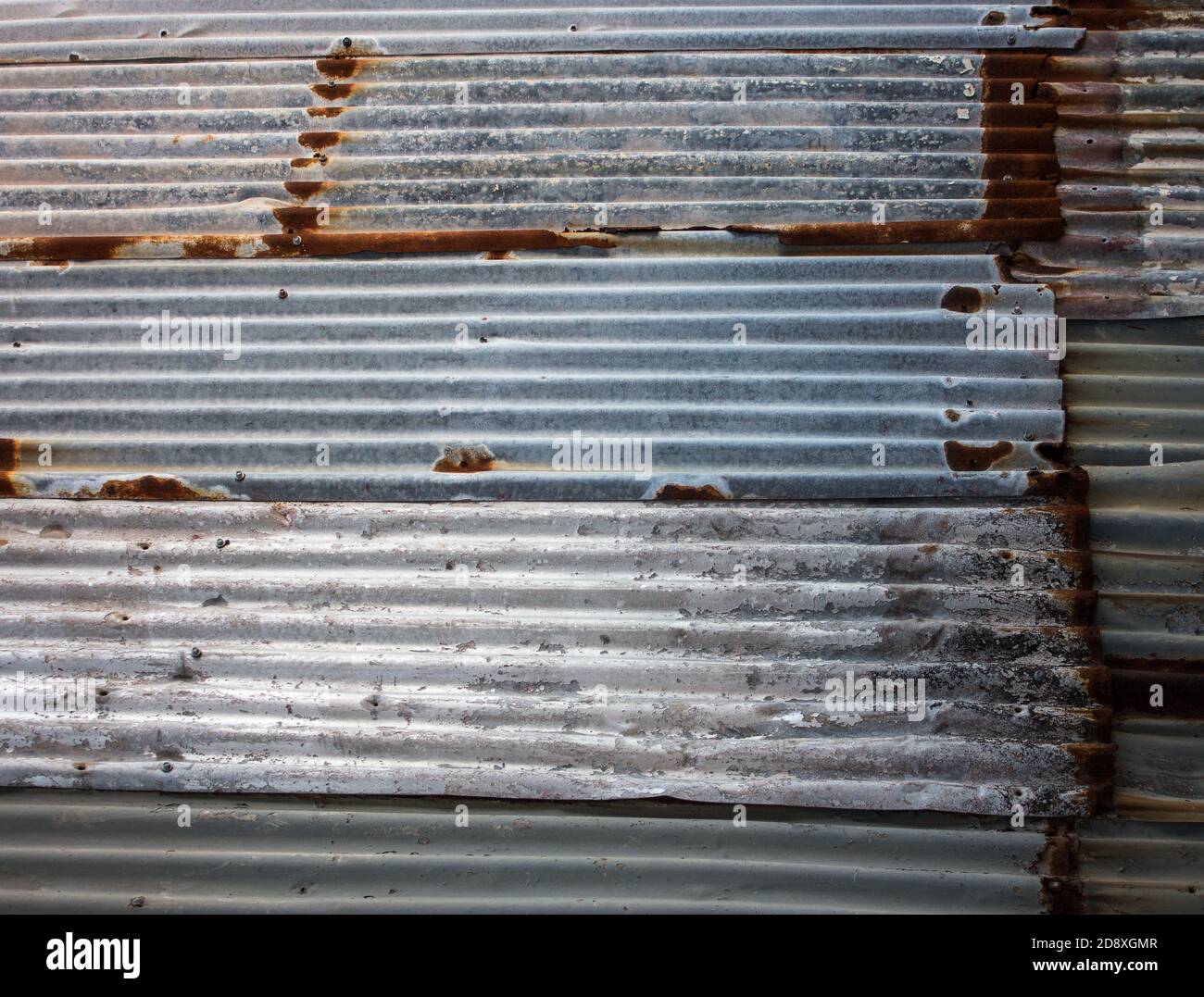 Rusting weathered corrugated iron wall ideal as industrial background Stock Photo