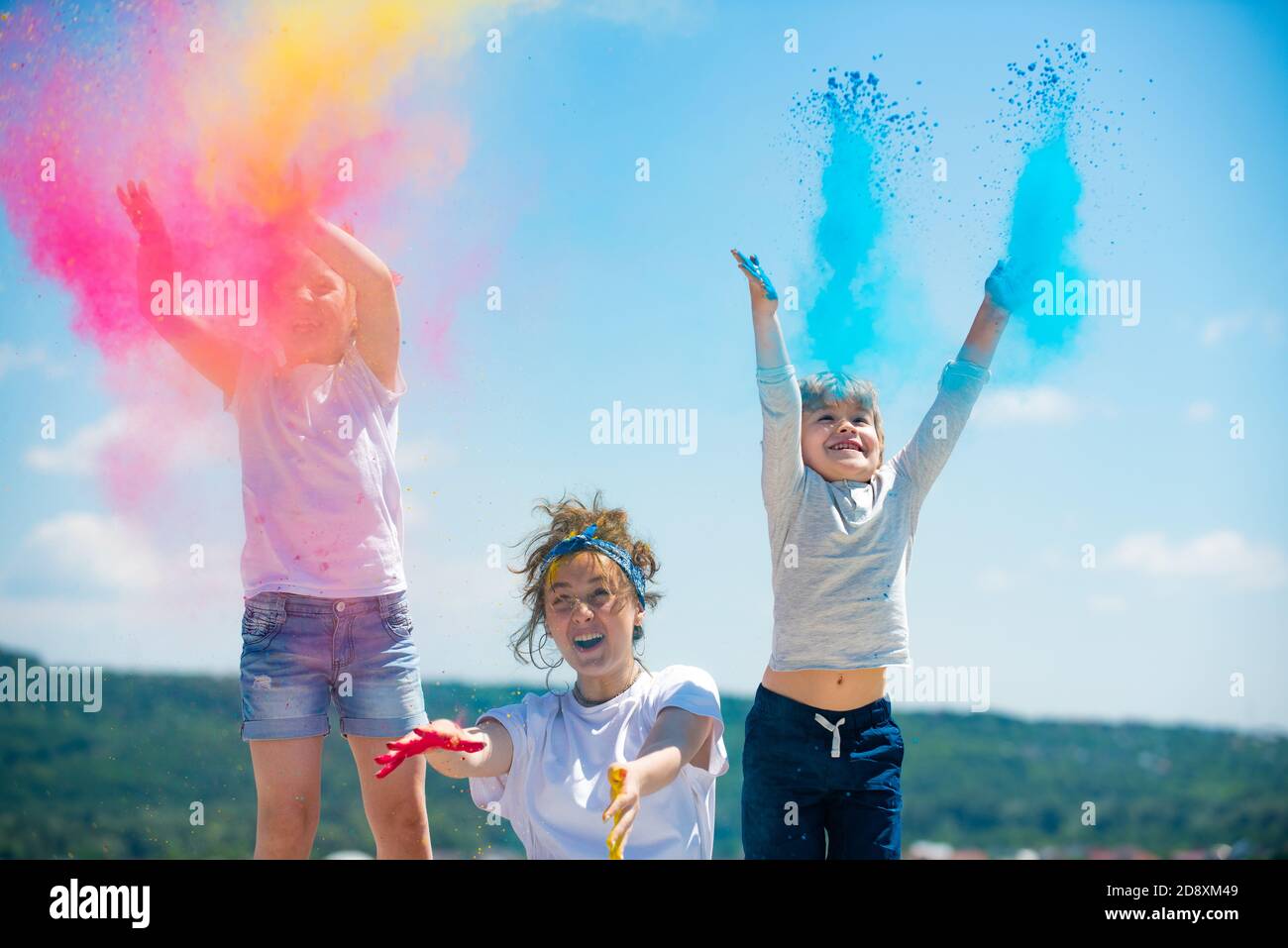 Excited children painted in the colors of Holi festival. Kids splashing colorful paint. Stock Photo