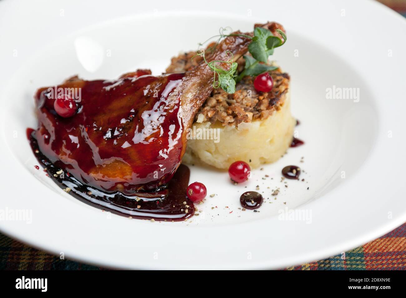 Duck leg Confit with chanterelles, mashed potatoes and raspberry sauce Stock Photo