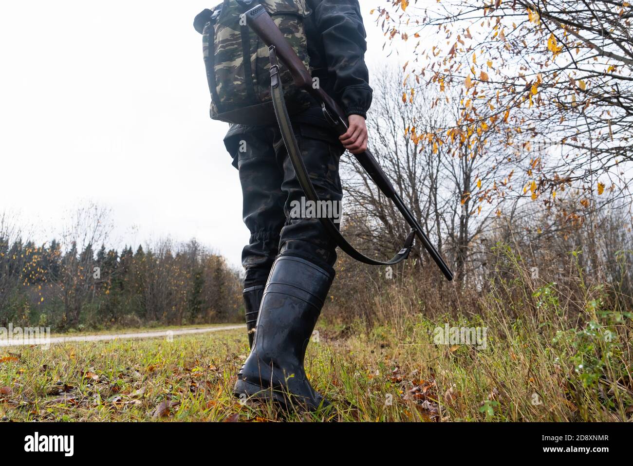 Hunter with a gun and a backpack in the a forest Stock Photo